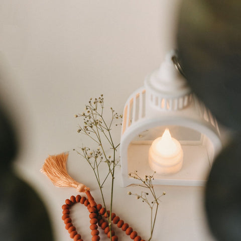 Femme musulmane lisant le Coran et faisant du dhikr pendant le Ramadan, avec une tasse de thé et un planner organisé pour optimiser son mois de jeûne.
